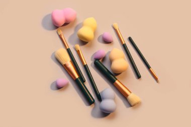 Bej arka planda makyaj süngerleri ve fırçalar