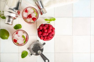 Taze ahududu mojito bardakları ve beyaz fayanslı böğürtlenli kase.