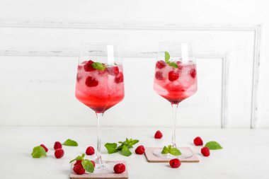 Beyaz arka planda bir bardak taze ahududu mojito.