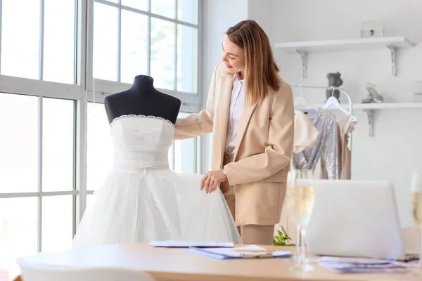 Female wedding planner with dress in office