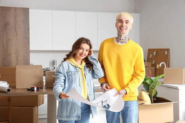 Young couple with house plan in kitchen on moving day