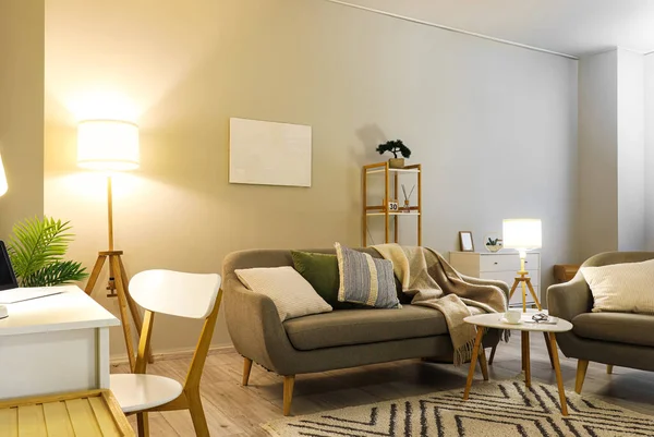 Gri kanepesi, koltuğu ve parlak lambaları olan oturma odasının içinde.