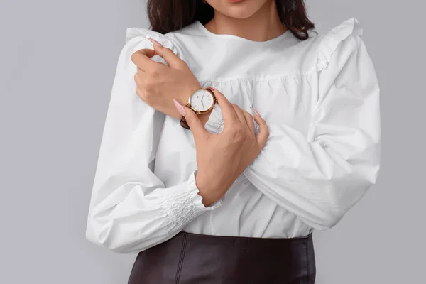 灰色の背景に腕時計を持つ美しい若い女性 — ストック写真
