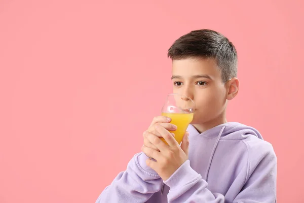 Mały Chłopiec Pijący Sok Pomarańczowy Różowym Tle — Zdjęcie stockowe