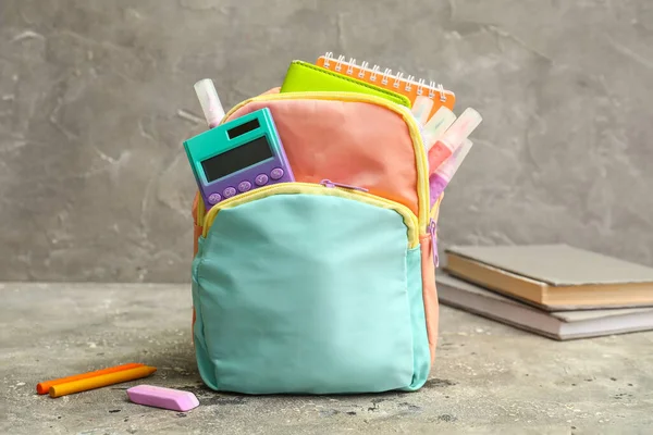 Kolorowy Plecak Szkolny Notebookami Kalkulatorem Markerami Szarym Stole Grunge Przy — Zdjęcie stockowe