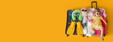 Çantanın içinde, sarı arka planda eşyaları olan, mesaj atmak için yeri olan, güzel bir kız çocuğu.