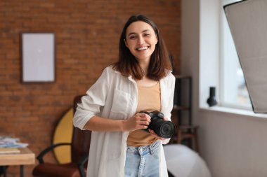 Stüdyoda profesyonel fotoğraf makinesi olan kadın fotoğrafçı.
