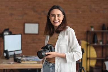 Stüdyoda profesyonel fotoğraf makinesi olan kadın fotoğrafçı.