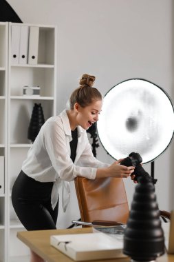 Stüdyoda profesyonel kamerası olan mutlu kadın fotoğrafçı.