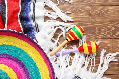 Meksika marakaları, sombrero şapkası ve ahşap arka planda serapla.