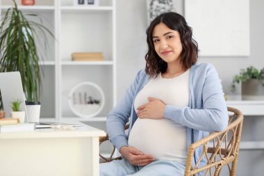 Ofiste çalışan hamile bir kadın.