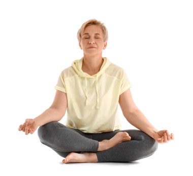 Beyaz arka planda yoga yapan olgun bir kadın.