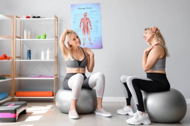 Fizyoterapisti olan genç bir kadın rehabilitasyon merkezinde yüz geliştirme egzersizi yapıyor.