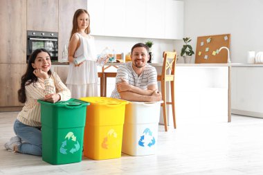 Mutfakta çöp bidonları olan bir aile.