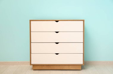 Mavi duvarın yanındaki beyaz çekmeceler çok şık.