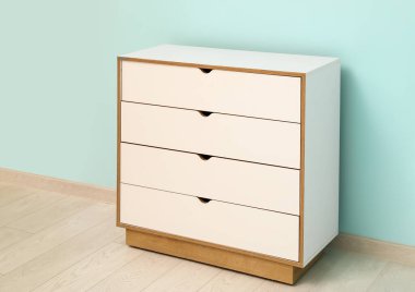 Renkli duvarın yanındaki beyaz çekmeceler şık.