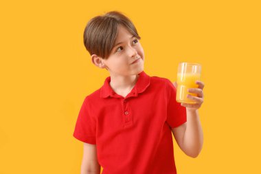 Arka planda bir bardak portakal suyu olan küçük çocuk.