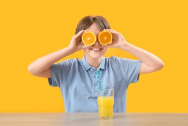 Arka planda portakal suyu ve meyve suyu bulunan küçük çocuk.