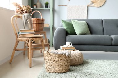 Oturma odasında kanepe, hasır sepet ve sandalye var.