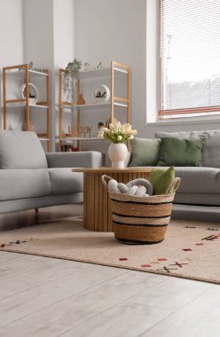 Kanepeleri, masası ve sepeti olan aydınlık oturma odasının içinde.