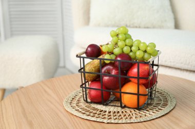 Oturma odasındaki kahve masasının üzerinde meyve sepeti, yakın plan.