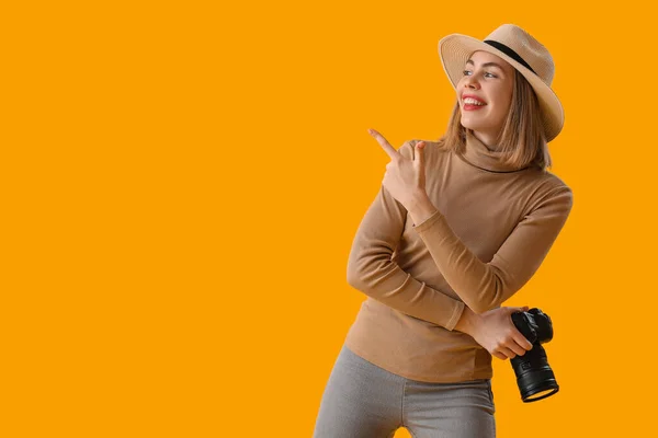 Vrouwelijke Fotograaf Met Professionele Camera Wijst Naar Iets Gele Achtergrond — Stockfoto