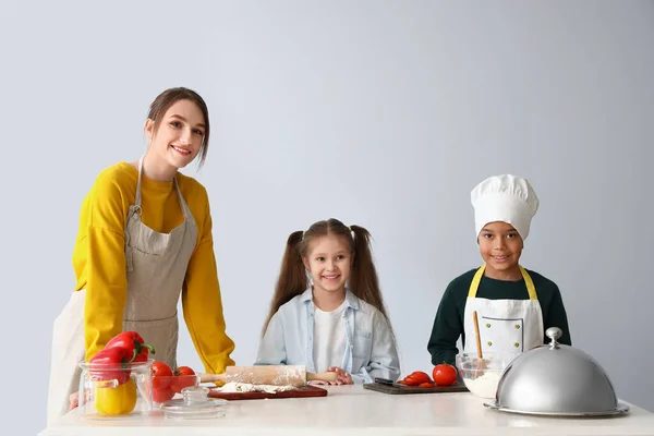 Chef Femenino Con Niños Pequeños Durante Clase Cocina Sobre Fondo —  Fotos de Stock