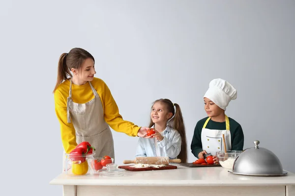 Chef Femenino Con Niños Pequeños Durante Clase Cocina Sobre Fondo —  Fotos de Stock