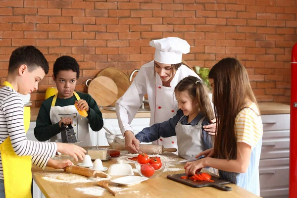 Kobieta Kucharz Grupą Małych Dzieci Przygotowujących Pizzę Podczas Lekcji Gotowania — Zdjęcie stockowe