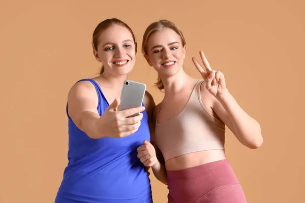 Desportivas Jovens Mulheres Tomando Selfie Fundo Bege — Fotografia de Stock