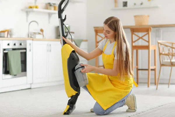 台所の掃除機が付いている若い女性 — ストック写真