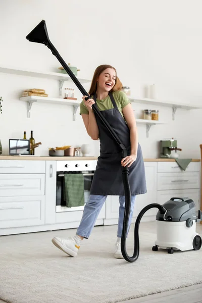 キッチンで掃除機ダンスをしている若い女性 — ストック写真