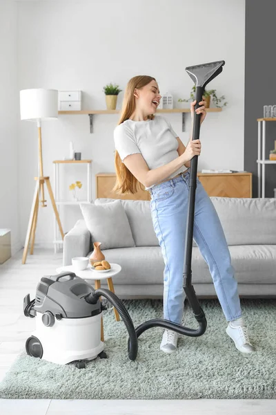 自宅で歌っている掃除機を持つ若い女性 — ストック写真
