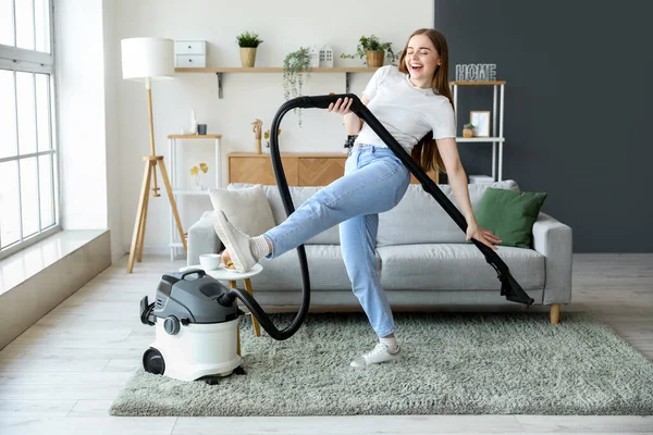 自宅でダンスをする掃除機を持つ若い女性 — ストック写真