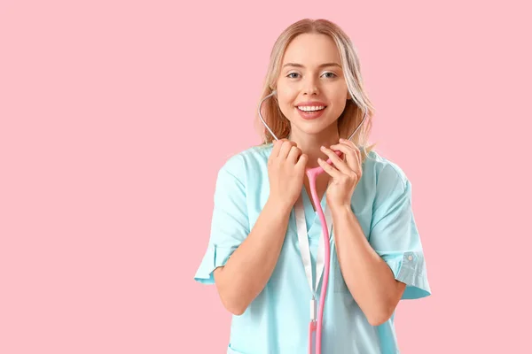 女性医療インターンとともに聴診器でピンクの背景 — ストック写真
