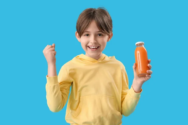 Szczęśliwy Chłopczyk Butelką Soku Pomarańczowego Niebieskim Tle — Zdjęcie stockowe
