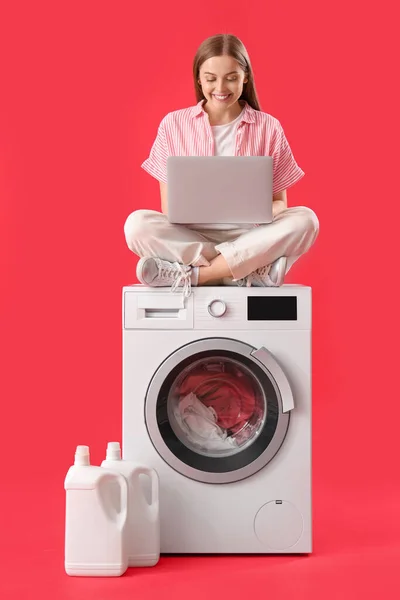 Mulher Bonita Com Laptop Moderno Sentado Máquina Lavar Roupa Contra — Fotografia de Stock