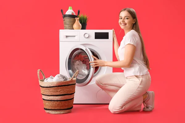 Mulher Bonita Colocando Roupa Suja Máquina Lavar Roupa Fundo Vermelho — Fotografia de Stock