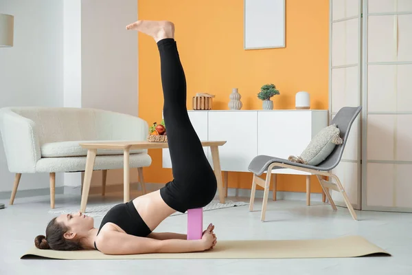 Sportig Ung Kvinna Utövar Yoga Med Block Hemma — Stockfoto