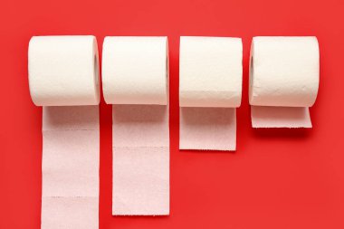 Kırmızı arkaplanda tuvalet kağıdı ruloları