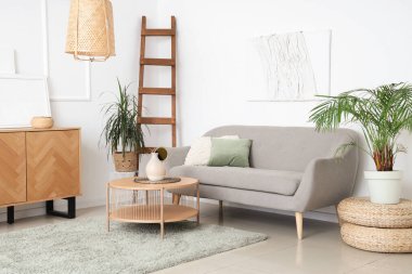 Kanepesi, masası ve çiçekleri olan bir oturma odası.