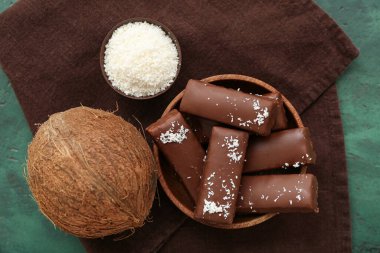 Yeşil arka planda lezzetli çikolata kaplı hindistan cevizi şekerlemeleri.