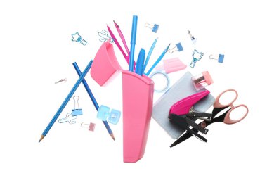 Beyaz zemin üzerinde farklı kırtasiye malzemesi olan uçan kalem kutusu