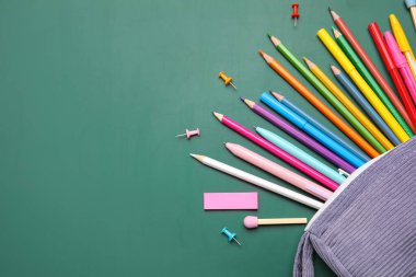 Yeşil arka planda farklı okul kırtasiyesine sahip kalem kutusu