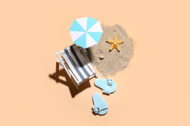 Bej arka planda mini şemsiyeli, şezlonglu ve plaj aksesuarlı yaratıcı yaz kompozisyonu