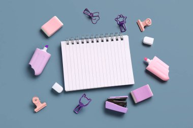 Mavi arkaplanda farklı kırtasiye malzemesi olan defter