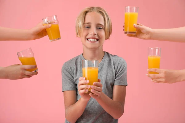 Little boy and female hands with orange juice on pink background