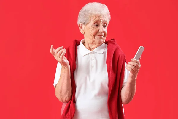 Confused Senior Woman Mobile Phone Red Background — Stock Photo, Image