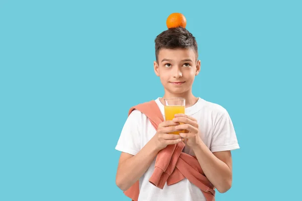 Mały Chłopiec Szklanką Soku Pomarańczą Niebieskim Tle — Zdjęcie stockowe