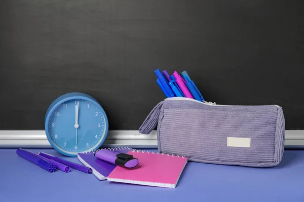 Pencil Case Different School Stationery Alarm Clock Purple Table Blackboard — Stock Photo, Image